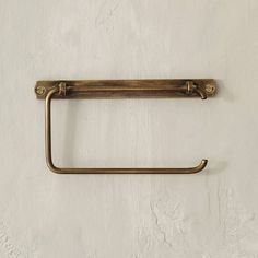 an antique brass towel ring hangs on a white wall with no one in the room