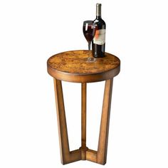 a wooden table with a wine glass and bottle on it