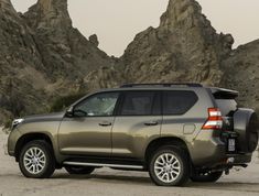 a silver suv parked in front of some mountains