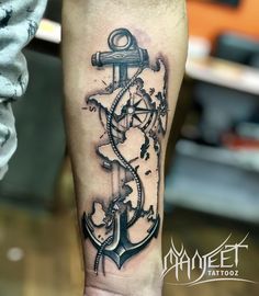 a man with a tattoo on his leg that has an anchor and compass in it