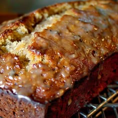 a loaf of bread with icing on top of it sitting on a cooling rack