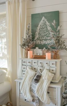 a christmas mantle with stockings and candles on it