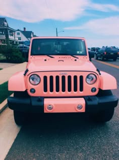 a pink jeep is parked on the street