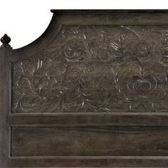 an ornate wooden headboard with carvings on the top and bottom panel, in dark wood