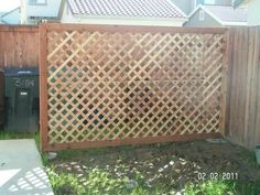 a wooden fence next to a trash can