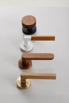 an assortment of wooden handles and knobs on a white surface