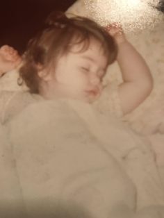 a small child laying on top of a bed