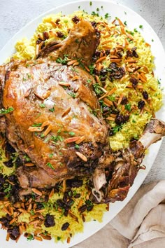 a white plate topped with meat and rice covered in parsley garnishments