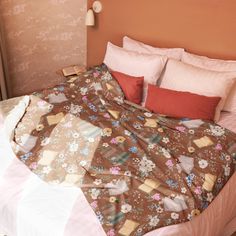 an unmade bed with pink and brown sheets