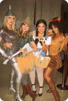 four women dressed in costumes posing for the camera