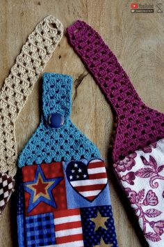 three crocheted tags with stars and hearts on them sitting on a wooden surface