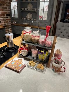 a kitchen counter topped with lots of cookies and desserts next to a stove top oven