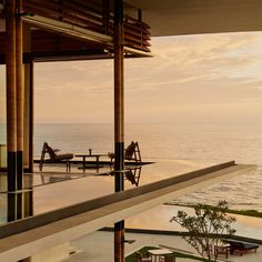 an outdoor dining area overlooking the ocean at sunset