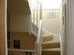 an open door leading to a stairway with pictures on the wall and carpeted floor