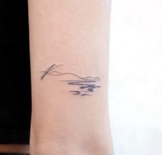 a woman's arm with a small tattoo on the left side of her wrist