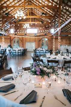 the tables are set up for an elegant wedding reception with candles and centerpieces