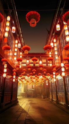 lanterns are hanging from the ceiling in an alleyway at night with lights on them