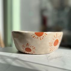 an orange and white bowl sitting on top of a counter