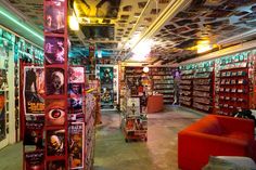 a room filled with lots of books on shelves next to red couches and chairs