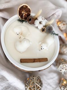 a bowl filled with white liquid next to an orange and cinnamon