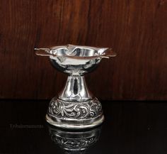 a silver bowl sitting on top of a wooden table