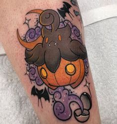 a person with a tattoo on their leg that has an elephant and pumpkin on it