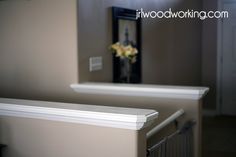 a vase with flowers sitting on top of a white shelf next to a mirror and railing