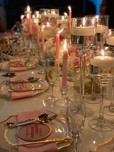 a table set with candles, plates and napkins for a formal dinner or party