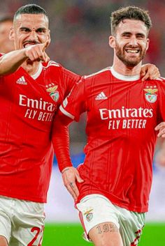 two men in red soccer uniforms standing next to each other with their arms around one another