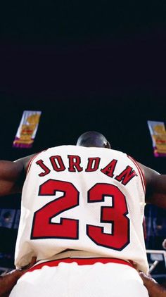 the back of a basketball player with his jersey draped over his head and hands behind him