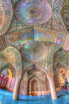 the inside of an ornate building with columns and stained glass windows