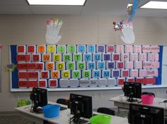 an empty classroom with desks and computer monitors on the wall in front of it