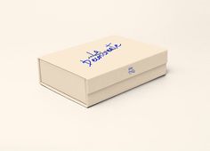 a white box with blue writing on the lid and bottom is sitting on a plain surface