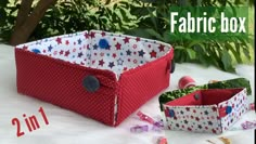 two red and white fabric storage boxes sitting on top of a table next to each other