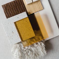 an assortment of different types of tiles on a white tablecloth with brown and yellow accents