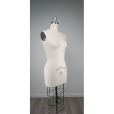 a white mannequin is standing on a black stand