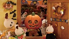 a group of stuffed animals standing in front of a halloween scene with pumpkins and bunnies