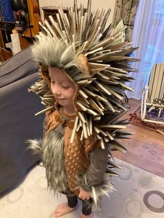 a young child dressed as a hedgehog with spikes on it's head and legs