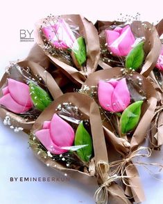 a bouquet of pink roses wrapped in brown paper