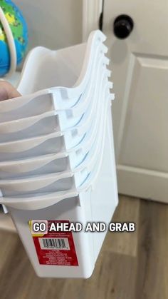 a person holding a stack of white plastic containers in their hand with the text go ahead and grab