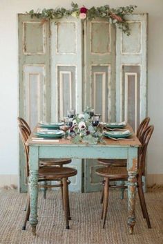 a dining room table with chairs and plates on it