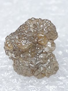 a piece of rock sitting on top of a white table covered in ice and snow