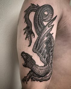 a man's arm with a dragon tattoo on it