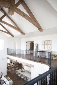 a living room filled with furniture and lots of wooden beamed ceiling beams on top of white walls