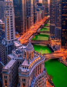 an aerial view of the chicago river and city buildings at night, with green water in the foreground