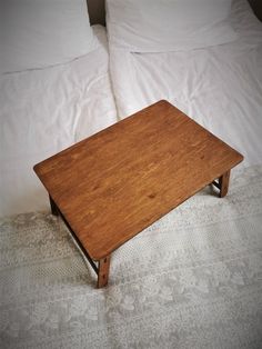 a wooden table sitting on top of a bed