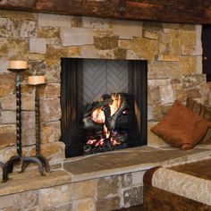 a fireplace with a fire in it surrounded by candles