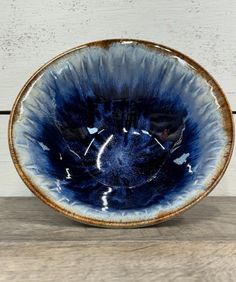 a blue and white bowl sitting on top of a wooden table