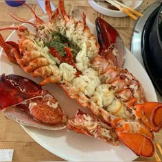 lobsters and other seafood on a plate with chopsticks