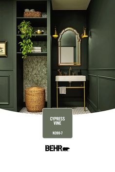 a bathroom with green walls and white counter tops, gold fixtures and a plant in the corner